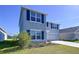 Two-story home boasts gray siding, dark shutters, well-maintained landscaping, and an attached two-car garage at 5470 Flint Hills Dr, Wimauma, FL 33598