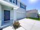 Front of a light blue home with a 2-car garage and a dark blue front door at 5470 Flint Hills Dr, Wimauma, FL 33598
