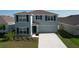 Two-story home with a two-car garage and neutral exterior paint at 5470 Flint Hills Dr, Wimauma, FL 33598