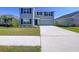 Charming two-story home with blue shutters and a well-kept lawn, adding to its appealing curb appeal at 5470 Flint Hills Dr, Wimauma, FL 33598