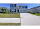 Inviting two-story home with blue shutters and fresh landscaping, enhancing its attractive curb appeal at 5470 Flint Hills Dr, Wimauma, FL 33598