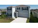 Two-story home with a two-car garage and neutral exterior paint at 5470 Flint Hills Dr, Wimauma, FL 33598