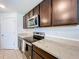 Close-up of a modern kitchen with dark wood cabinets, granite countertops, and stainless steel appliances at 5470 Flint Hills Dr, Wimauma, FL 33598