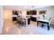 Spacious kitchen with dark wood cabinetry, stainless steel appliances, a center island with bar stools, and a dining table at 5470 Flint Hills Dr, Wimauma, FL 33598
