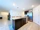 Bright kitchen featuring a center island with a double sink, stainless steel appliances, and white tile flooring at 5470 Flint Hills Dr, Wimauma, FL 33598