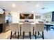 Modern kitchen with stainless steel appliances, granite countertops, a center island, and a dining area in the background at 5470 Flint Hills Dr, Wimauma, FL 33598