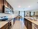 Spacious kitchen and dining area with dark cabinets, granite countertops, stainless appliances, and stylish decor at 5470 Flint Hills Dr, Wimauma, FL 33598
