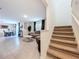Open concept living and dining area with tile floors and a staircase to the upper level at 5470 Flint Hills Dr, Wimauma, FL 33598