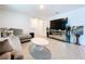 Open-concept living room with modern decor, tile floors, and ample natural light at 5470 Flint Hills Dr, Wimauma, FL 33598