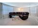 Upstairs living area with a comfortable leather sectional and ample natural light from the windows at 5470 Flint Hills Dr, Wimauma, FL 33598