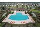 An aerial view of a large community pool with lounge chairs and landscaping at 5470 Flint Hills Dr, Wimauma, FL 33598