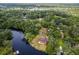 Aerial view of a home surrounded by lush trees, waterways, and a serene lake nearby at 5832 Portal Rd, New Port Richey, FL 34655
