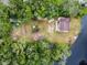 Aerial view reveals a waterfront lot with some buildings surrounded by lush trees and a dark river at 5832 Portal Rd, New Port Richey, FL 34655