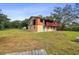 Exterior of a two-story home, with some repairs needed, set in a spacious, grassy yard at 5832 Portal Rd, New Port Richey, FL 34655