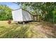 Exterior of manufactured home with grass yard, deck, and mature trees at 5832 Portal Rd, New Port Richey, FL 34655