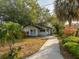 Charming single-story home with a concrete walkway, complemented by lush landscaping and mature trees at 593 Marmora Ave, Tampa, FL 33606