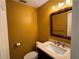 Cozy half bath featuring a vanity with marble countertop and modern fixtures, set against a yellow wall at 750 Island Way # 101, Clearwater Beach, FL 33767