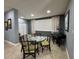 Dining area with a table, chairs, piano, white shutters, neutral colors, and tile floors at 750 Island Way # 101, Clearwater Beach, FL 33767