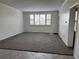 Bright living room with neutral carpet, large windows, and white walls, creating a clean and inviting atmosphere at 750 Island Way # 101, Clearwater Beach, FL 33767