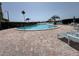 Outdoor pool surrounded by palm trees and lounge chairs with brick pavers at 750 Island Way # 101, Clearwater Beach, FL 33767