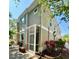 Townhouse exterior featuring a screened-in patio and manicured landscaping at 7543 Red Mill Circle Cir, New Port Richey, FL 34653