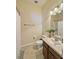 Well-lit bathroom featuring a sink, toilet, shower with white tiled wall, and a mirrored vanity at 7543 Red Mill Circle Cir, New Port Richey, FL 34653