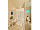 Cozy bathroom with shower and tub combination, decorative shelving, and a small window at 7543 Red Mill Circle Cir, New Port Richey, FL 34653