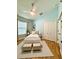 Stylishly staged bedroom with a bed, hardwood floors, area rug, fan, and plenty of natural light at 7543 Red Mill Circle Cir, New Port Richey, FL 34653