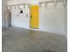 Spacious garage with white block walls, open shelving, and bright yellow door at 7543 Red Mill Circle Cir, New Port Richey, FL 34653