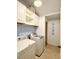 Bright laundry room featuring a washer, dryer, storage cabinets and decorative backsplash at 7543 Red Mill Circle Cir, New Port Richey, FL 34653