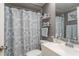 Well-lit bathroom with blue accents, a decorative shower curtain, and a mirrored vanity at 7901 Marlboro Dr, Port Richey, FL 34668