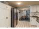 Bright kitchen area with white cabinets, stainless steel refrigerator, and adjoining dining space at 7901 Marlboro Dr, Port Richey, FL 34668