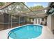 Sparkling pool enclosed within a screened patio featuring lighting and comfortable seating, perfect for relaxation and recreation at 7901 Marlboro Dr, Port Richey, FL 34668