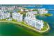 Beautiful aerial view of condo buildings nestled on the waterfront with lush landscaping and a community pool at 7932 Sailboat Key S Blvd # 406, South Pasadena, FL 33707