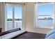 Bedroom view with a beautiful waterfront view from a large window and sliding glass doors at 7932 Sailboat Key S Blvd # 406, South Pasadena, FL 33707