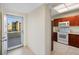 Efficient kitchen featuring cherry cabinets, white appliances, and a doorway leading to a balcony at 7932 Sailboat Key S Blvd # 406, South Pasadena, FL 33707