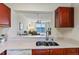 Modern kitchen featuring cherry cabinets, stainless steel sink and breakfast bar to the living room beyond at 7932 Sailboat Key S Blvd # 406, South Pasadena, FL 33707
