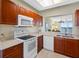 Inviting kitchen with cherry cabinets, white appliances, and an open view to the living space at 7932 Sailboat Key S Blvd # 406, South Pasadena, FL 33707