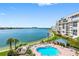 Waterfront condo featuring a beautiful pool with lounge chairs and stunning water views at 7932 Sailboat Key S Blvd # 406, South Pasadena, FL 33707