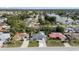 This aerial shot captures the house and the surrounding neighborhood with mature trees and nearby lake at 8030 Jasmine Blvd, Port Richey, FL 34668