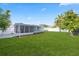 Expansive backyard showing a covered patio, well-kept lawn and partial fencing at 8030 Jasmine Blvd, Port Richey, FL 34668