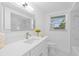 Bright bathroom with vanity, sink, and a large mirror at 8030 Jasmine Blvd, Port Richey, FL 34668
