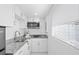 A clean kitchenette featuring granite countertops, stainless steel microwave and sink at 8030 Jasmine Blvd, Port Richey, FL 34668