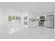 Spacious living area adjacent to kitchen with bright white tile floors and ample light at 8030 Jasmine Blvd, Port Richey, FL 34668