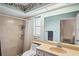 Bathroom with a large mirror, tiled shower, toilet, and floral ceiling border at 8405 Divot Way, Port Richey, FL 34668
