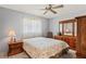Cozy bedroom with neutral walls, a large window, and traditional wooden furniture at 8405 Divot Way, Port Richey, FL 34668