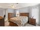 Bedroom with a ceiling fan, warm wood furniture, and soft natural lighting at 8405 Divot Way, Port Richey, FL 34668