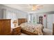 Bedroom with a ceiling fan, warm wood furniture, and soft natural lighting at 8405 Divot Way, Port Richey, FL 34668