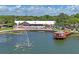 Community clubhouse featuring a pool, lounge area, and waterfront gazebo on a tranquil pond at 8405 Divot Way, Port Richey, FL 34668