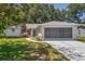 Charming single-story home featuring a well-maintained lawn and attached two-car garage at 8405 Divot Way, Port Richey, FL 34668
